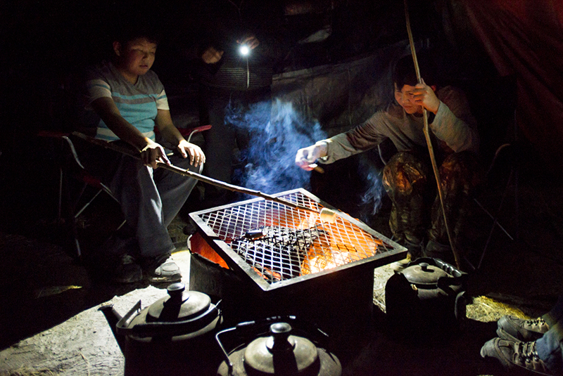 Maverick Simba-Canadien, Tarek Chicot and Dawson Landry roast marshmallows over the campfire. Photo: Pat Kane.