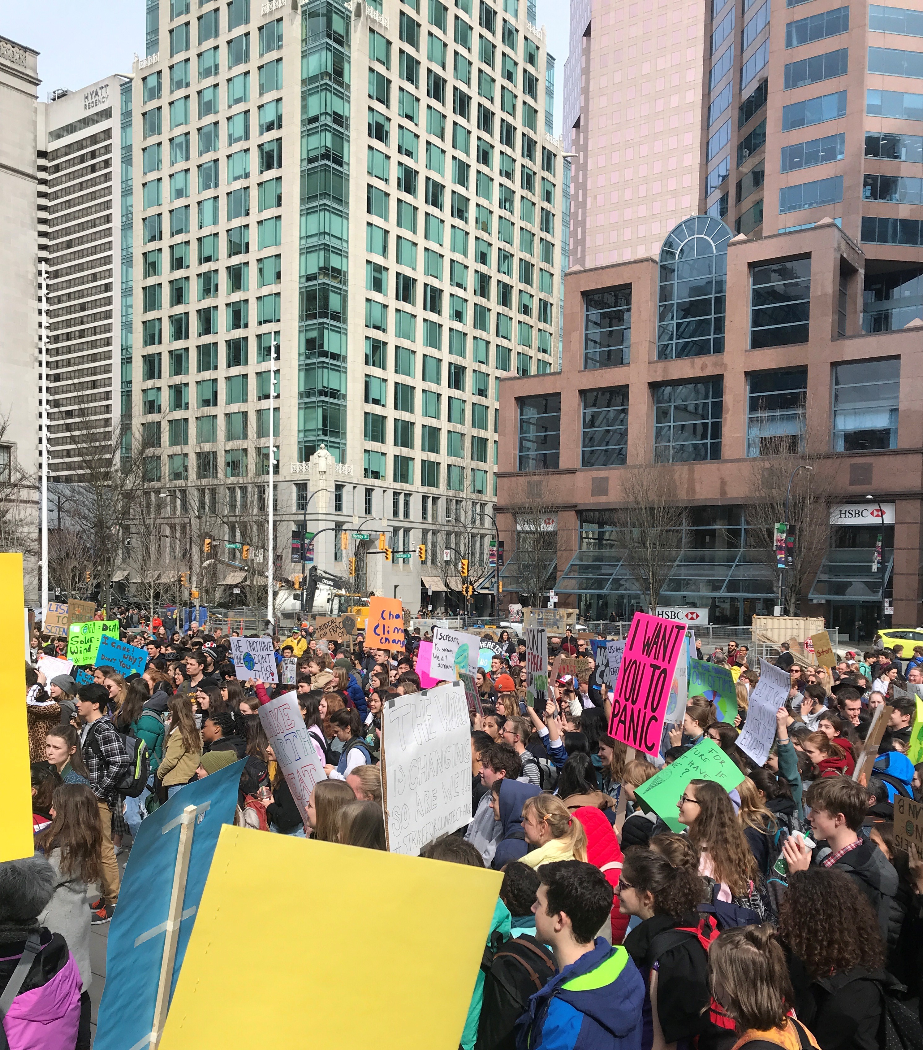 A group of thousands holding signs in downtown Vancouver to advocate for climate justice.
