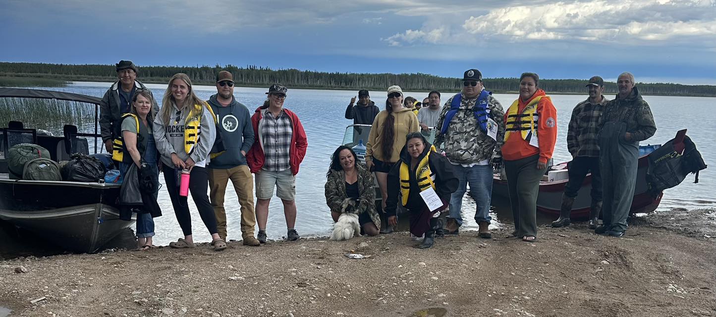 Attendees of the Sîhtoskâtowin Program Gathering taking a group photo and smiling at the camera.